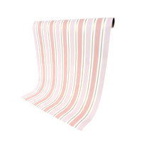 Unrolled pink striped table runner hanging from roll, gold foil stripes visible