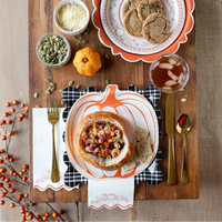 Tablescape with plaid charger under pumpkin plate and gold flatware