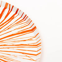 Closeup edge of Radiance orange 10.5 in dinner plate, glossy rim lines