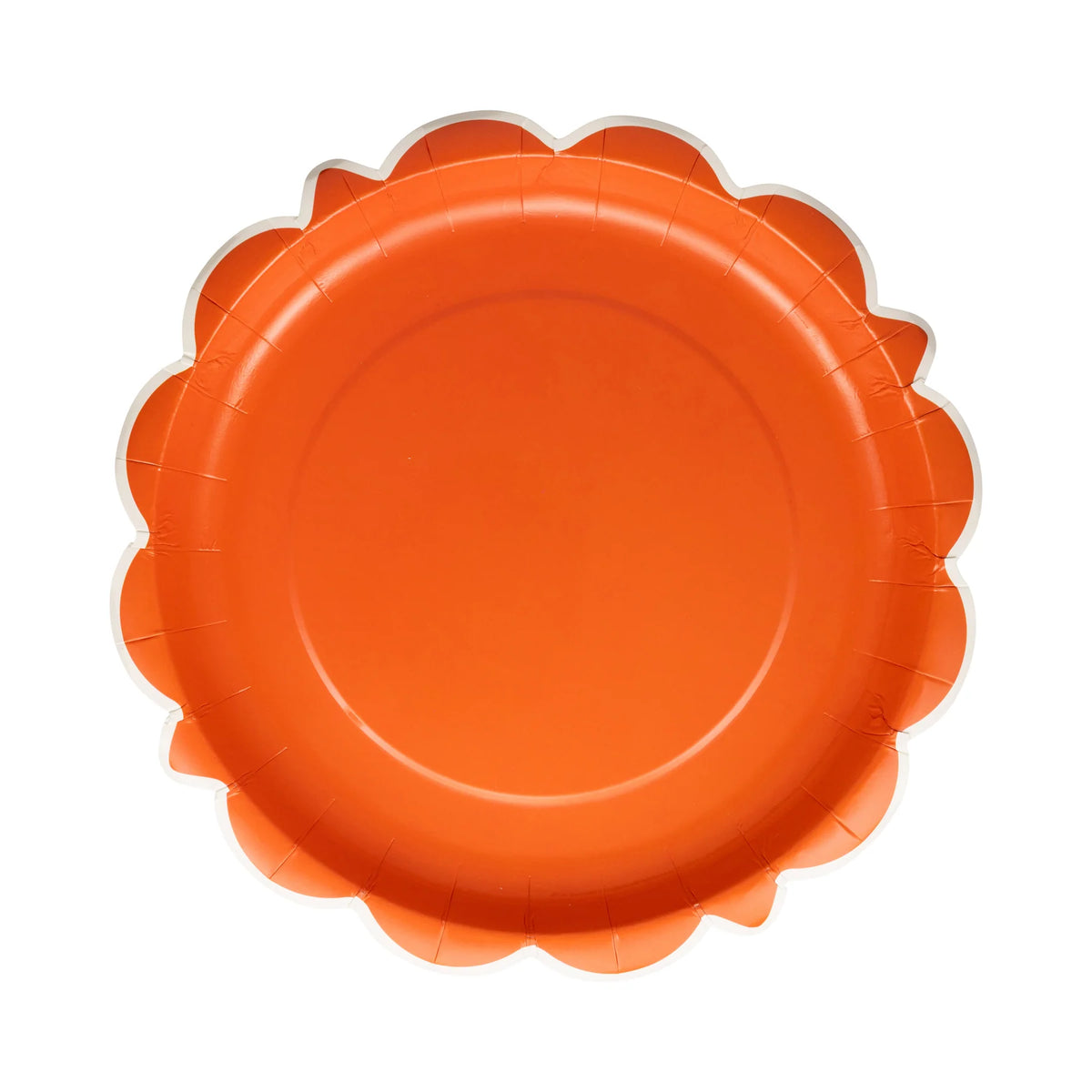 Single rust orange scalloped round plate on white background