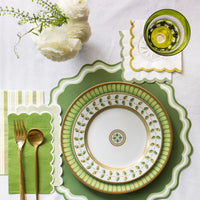 Green place setting styled with layered scallop paper cocktail napkins