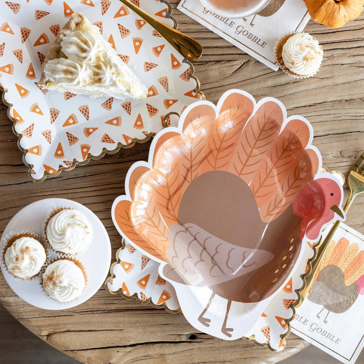Table styled with turkey shaped turkey plates, pie and fall decor