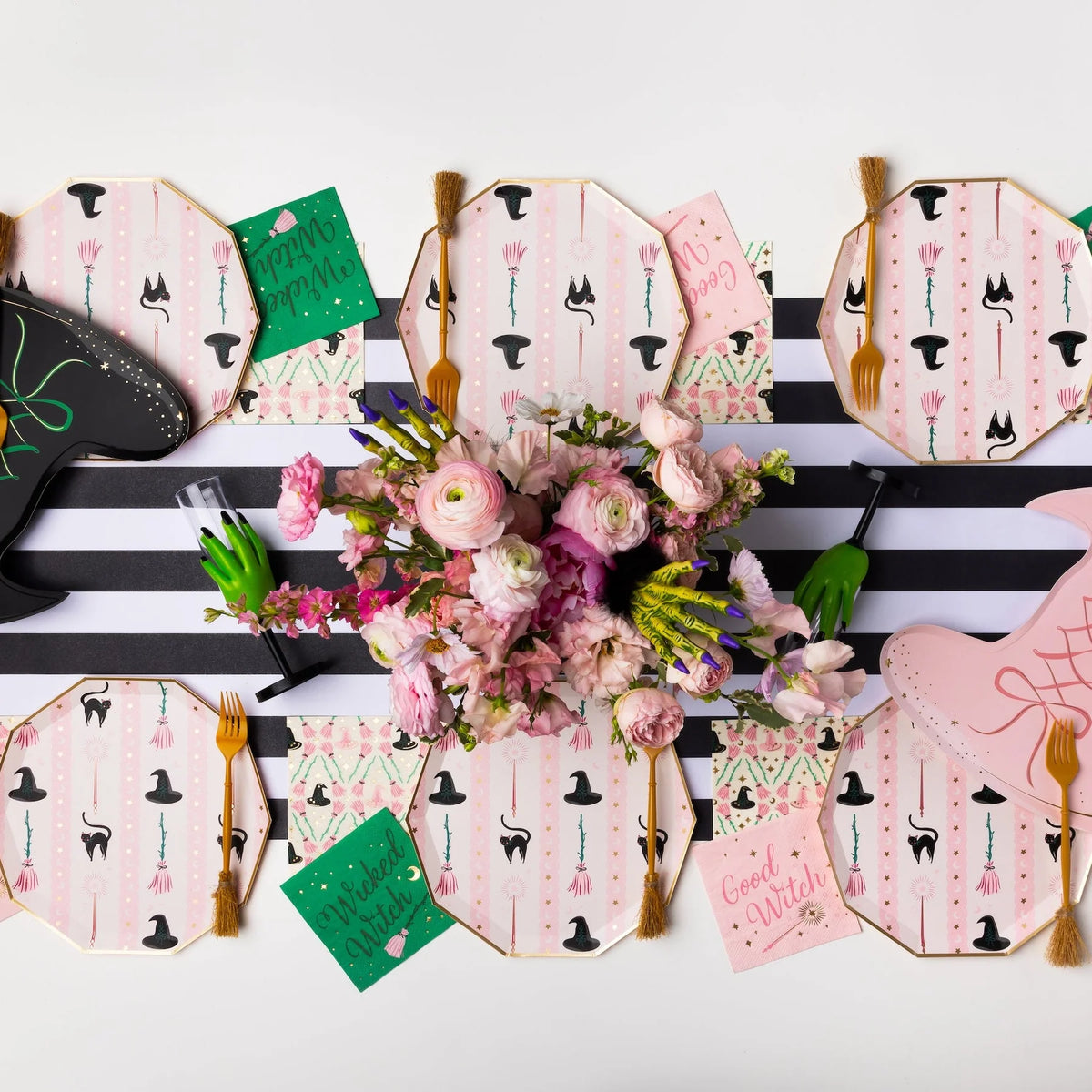 Overhead tablescape showing witch hat and broom lunch napkins with plates and flowers