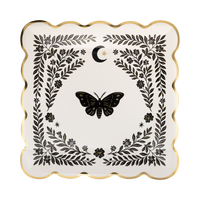 Top view of cream moonlight moth square paper dinner plate with gold foil scalloped edges and black botanical illustration against white background.