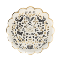 Angled overhead of the Moonlight Halloween plate showing the full symmetrical folk-art moth and botanical illustration and gold foil scalloped edge.