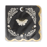 Close-up of the moth cocktail napkin showing the cream moth, laurel wreath, crescent moon, and gold foil scalloped edge detail on the black base.