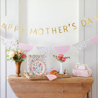 Mother’s Day table setup with floral plates, banner, and spring décor