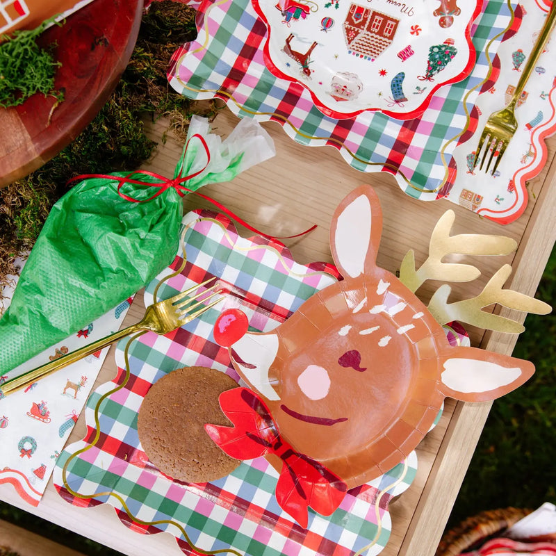 Multicolor gingham square paper plates layered under a reindeer plate and a Merry + Bright plate; other plates, napkins, and fork shown separately, not included