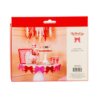 Back of packaging showing pink and red felt bow banner styled on a Valentine party table