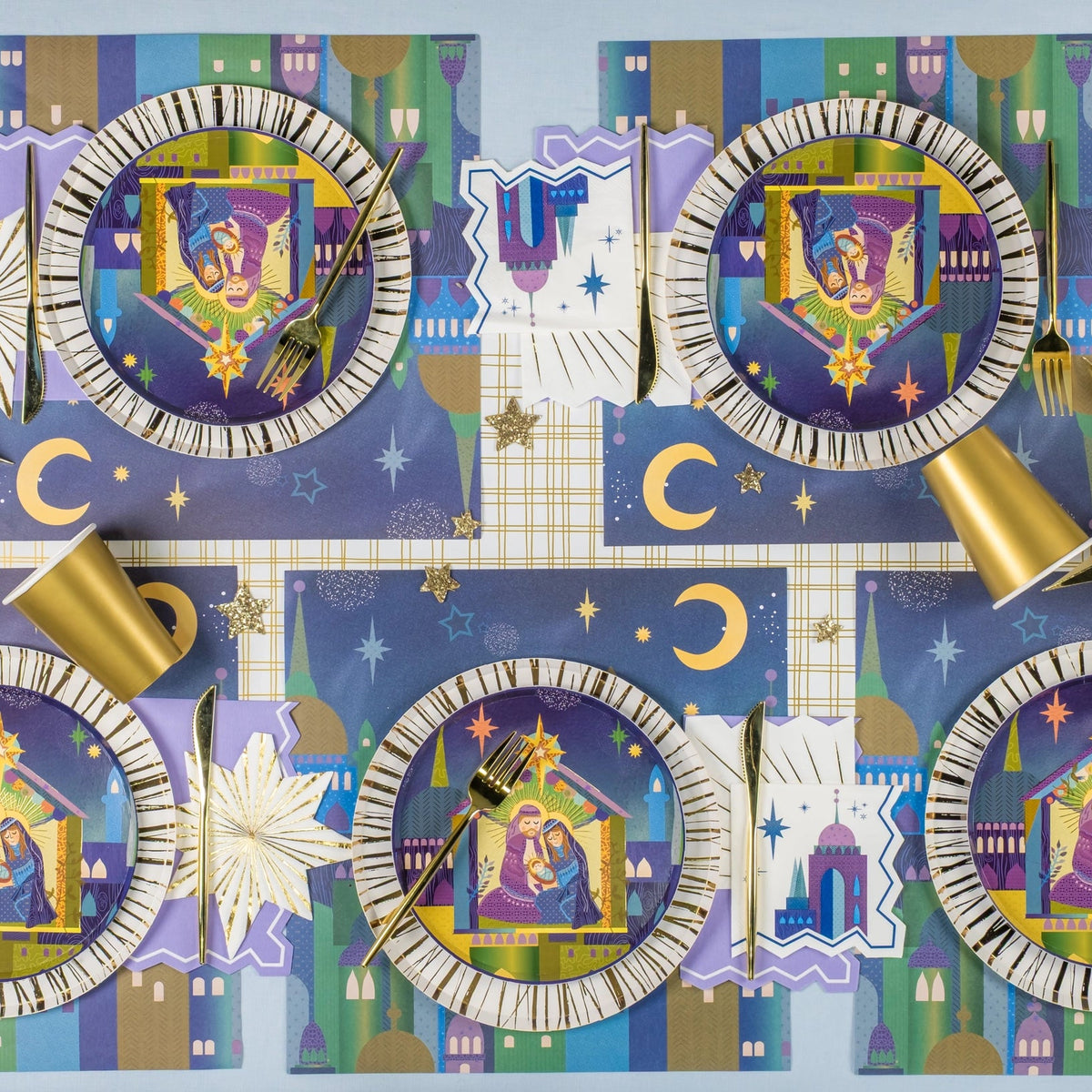 Tablescape with four place settings, gold accents, and moon/star mats