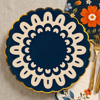 Navy folk doily plate on linen with a gold fork and navy floral napkins