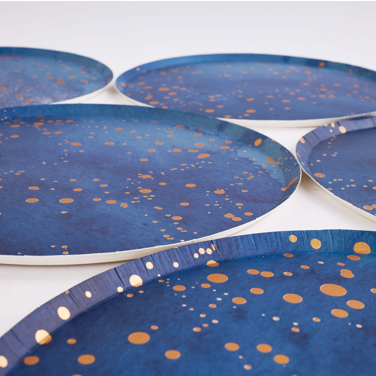 Navy gold-speckle paper plates arranged showing the round rim and finish