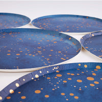 Navy gold-speckle paper plates arranged showing the round rim and finish