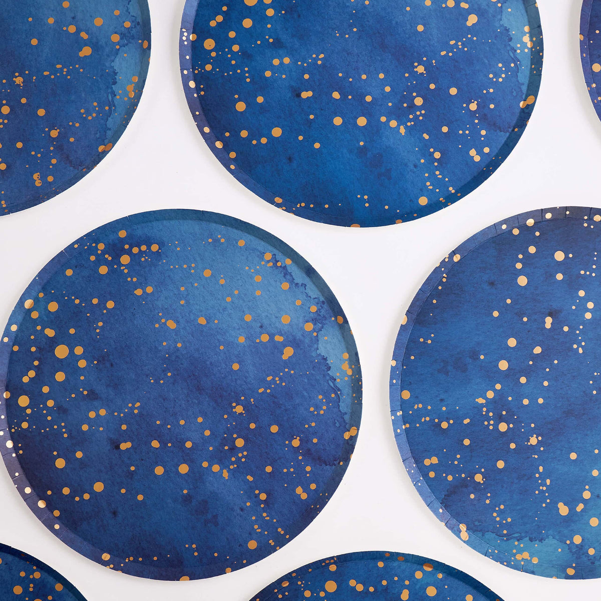 Group of navy and gold galaxy paper plates arranged overhead