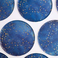 Group of navy and gold galaxy paper plates arranged overhead