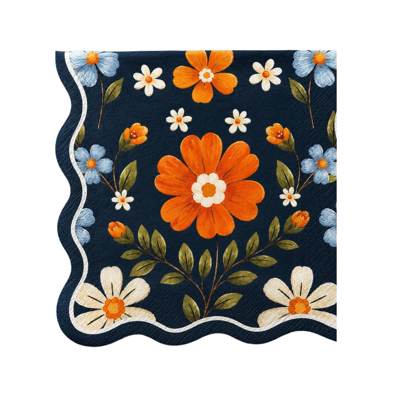 Navy lunch napkin with an allover folk floral print in orange, cream, and blue and a white wavy edge