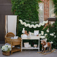 Neutral baby shower setup with cream tissue bunting banner
