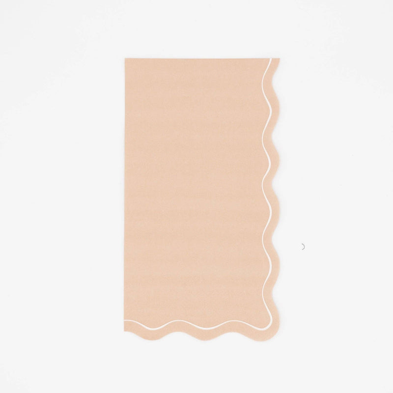 Solid light brown guest towel in warm tan with a flowing scalloped white-outlined edge, flat view on white background.
