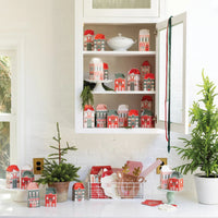 Large kitchen display showing many assembled North Pole Village houses and boxes set up as an advent calendar.