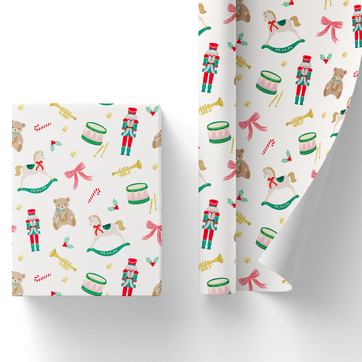 Wrapped gift box and partially unrolled nutcracker Christmas wrapping paper with rocking horses, drums, and teddy bears