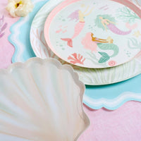 ocean paper plates with coral print charger and shell plate on pink table.
