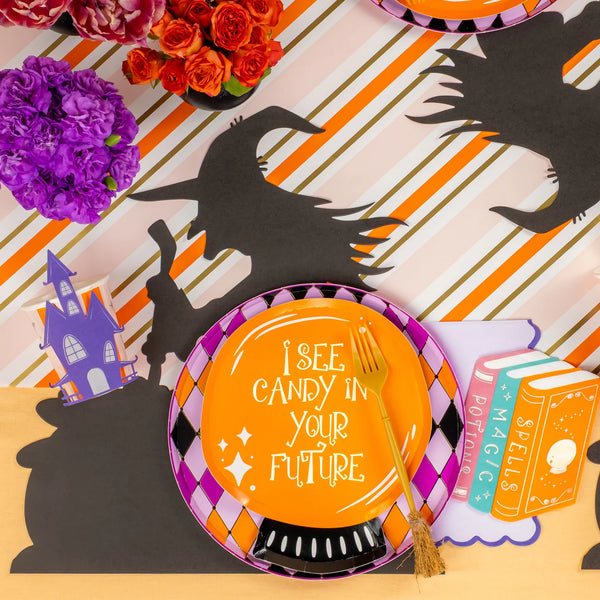 Crystal ball plate layered on a harlequin rim plate over a witch silhouette runner with florals.