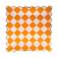 Orange and white checkered plate with scalloped edge on a white background