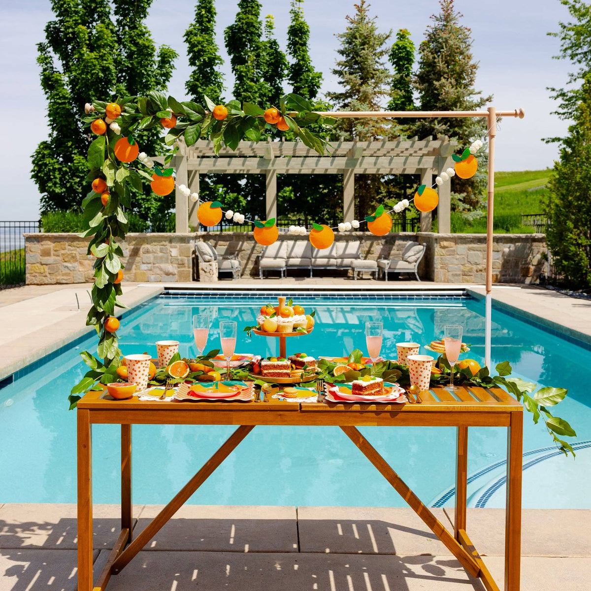 Orange felt banner hanging above a citrus-themed pool party table.