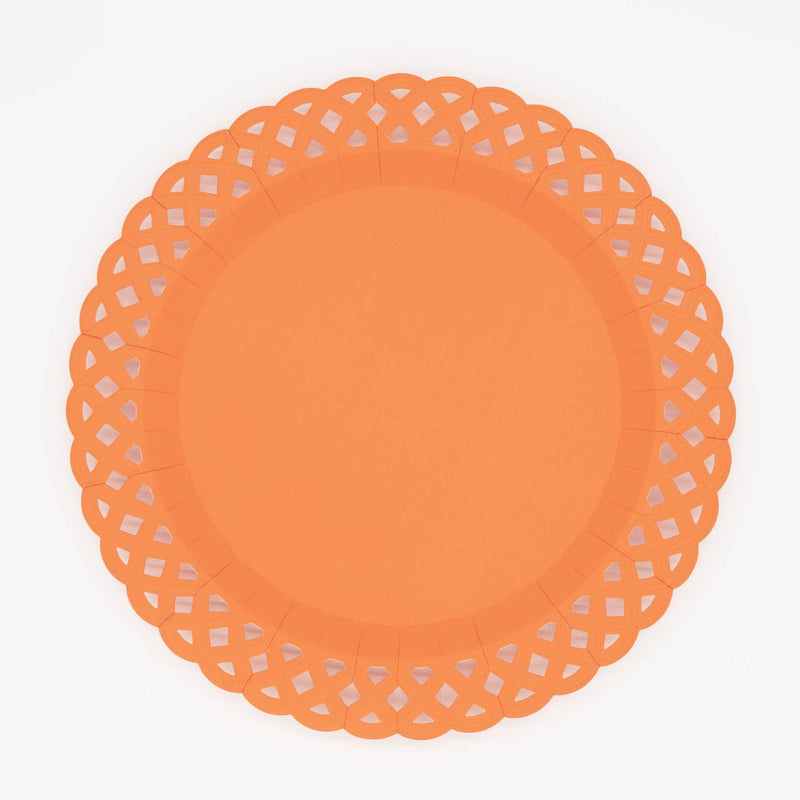 Rich pumpkin orange basketweave dinner plate with an embossed woven texture and a scalloped lattice cutout border, overhead view on white background.