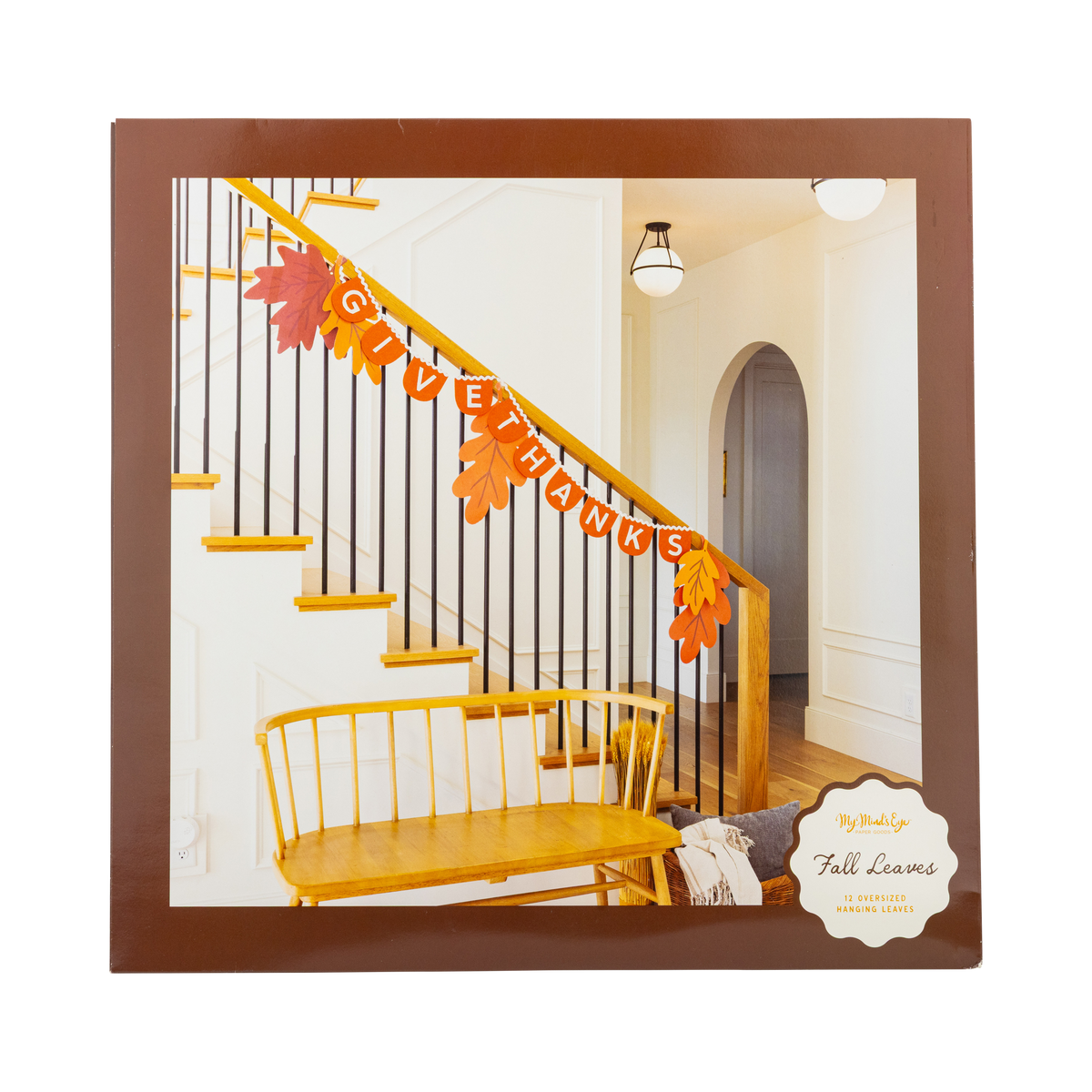 Colorful oversized autumn leaves in orange, red, yellow, and gold draped along a white staircase railing with black iron balusters — fall staircase decorations.
