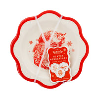 Packaged set of three bamboo plates showing the attached product tag detailing the three designs.