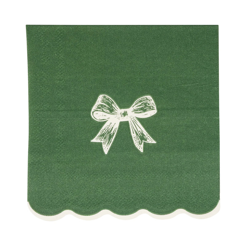 Close-up of a single dark green paper cocktail napkin featuring a white bow illustration and white scalloped edge.