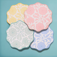 Four pastel floral colorways overlapping in a top-down view on teal.