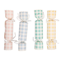 Four upright paper party crackers in assorted pink, blue, mint, and yellow gingham patterns with white ribbon bows and scalloped edges.
