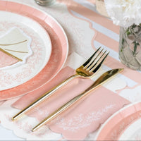 Pink guest towel paired with a pink lace plate and gold fork