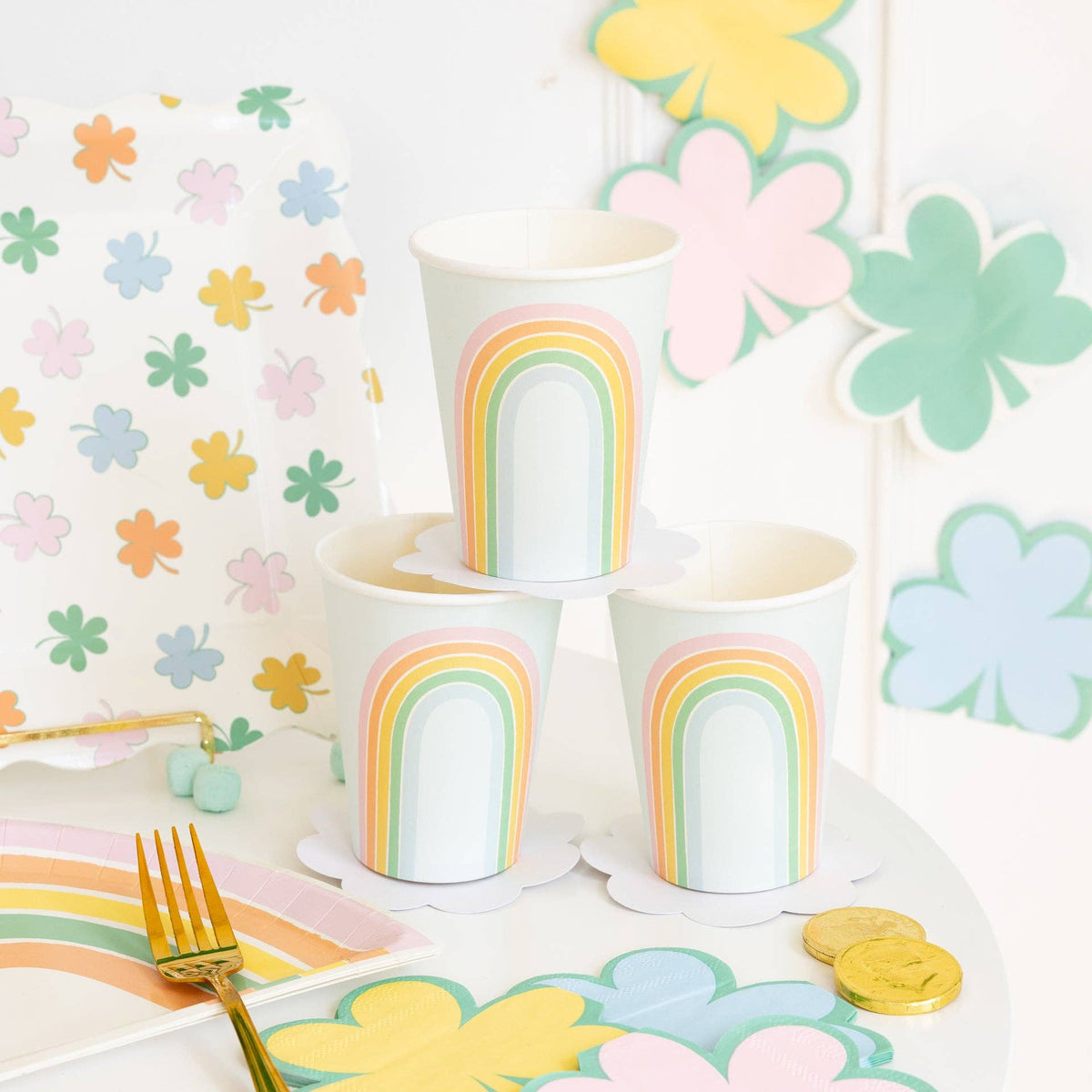 Pastel rainbow party cups styled on a St. Patrick’s Day table with shamrock and rainbow decor