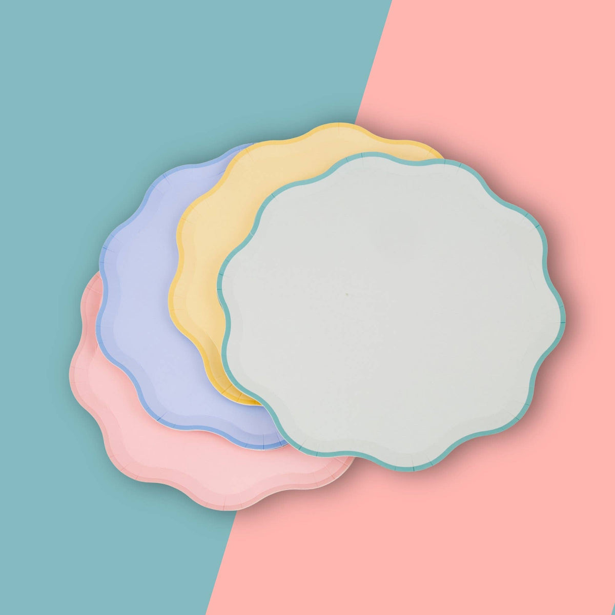 Fanned stack of pastel scalloped paper plates showing the wavy edges
