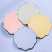 Fanned pastel scalloped plates on a teal background