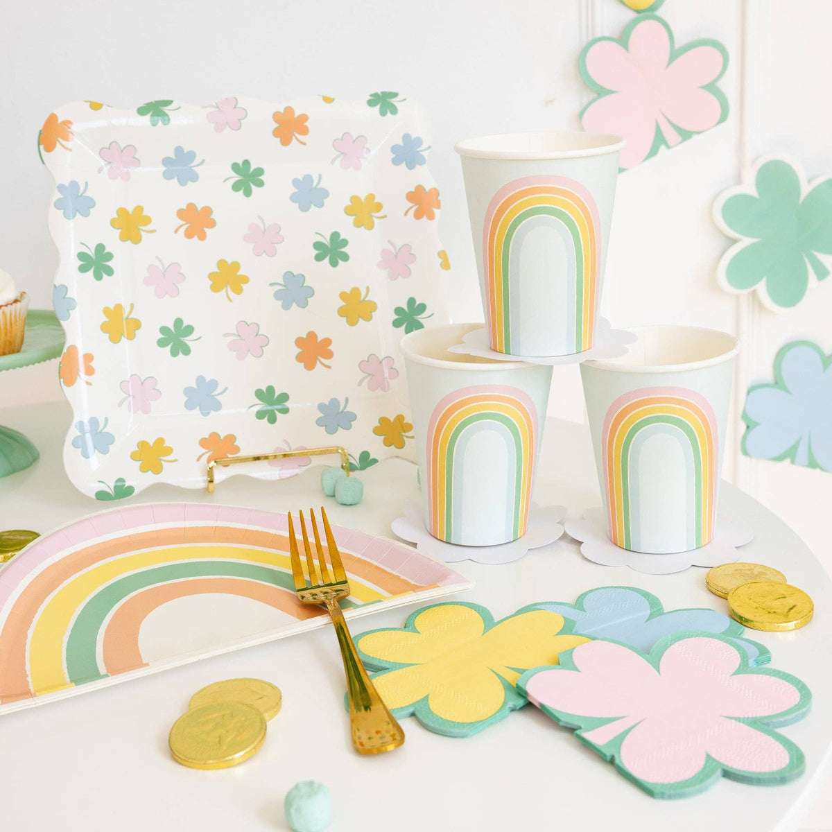 Pastel shamrock plates styled with rainbow cups and spring party table decor