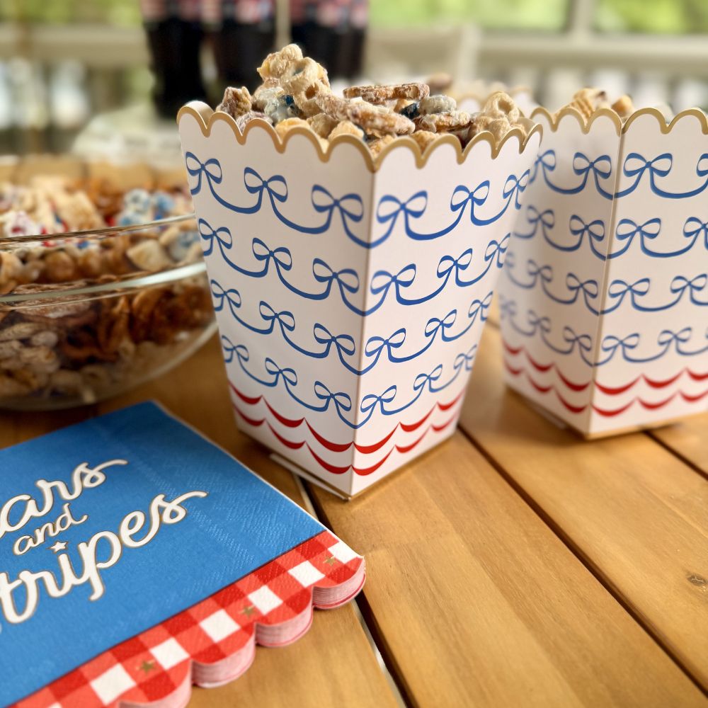 patriotic treat boxes styled on a party table with other 4th of July decorations.