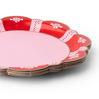 Angled stack of peppermint candy paper dinner plates showing the gold scalloped edge