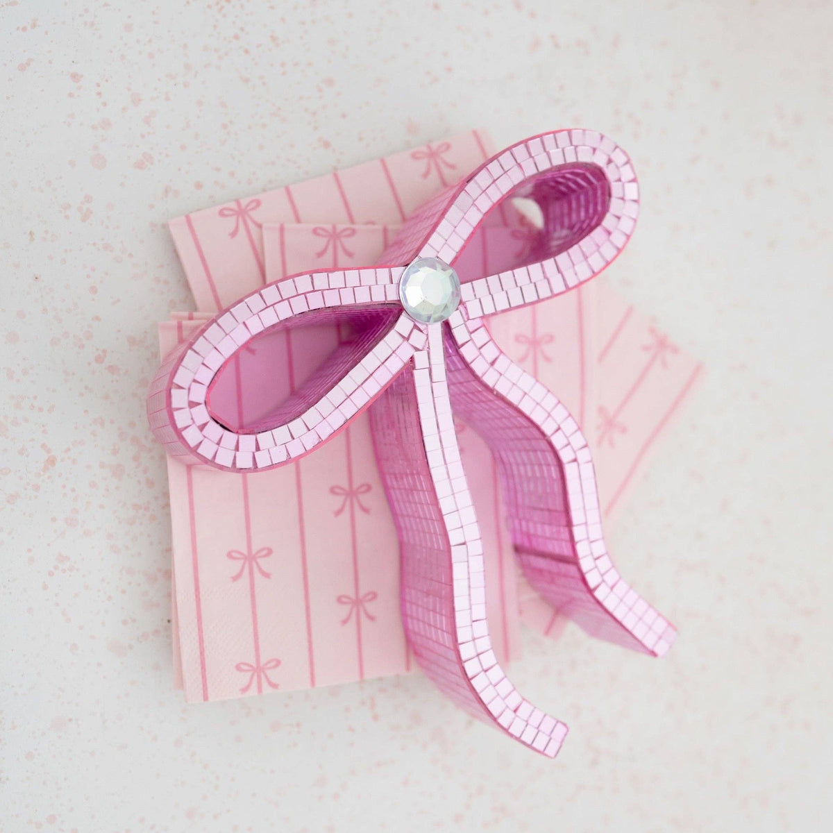 Stacked display of petal pink bow napkins styled with a pink bow decoration.