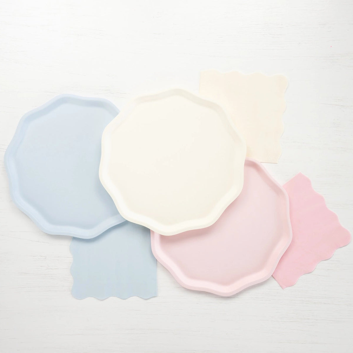 Pastel dinner plates in cream, blue, and petal pink layered together—compostable 10.5-inch plate set.