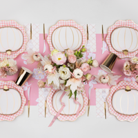 Pink gingham dinner plates styled on event table with coordinating décor.