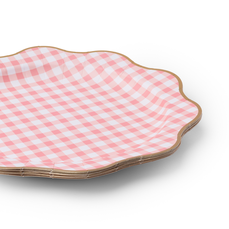 Stack of petal pink gingham dinner plates with gold foil edges