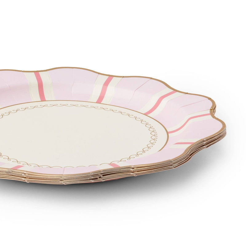 Close-up of a stack of petal pink paper dinner plates showing the pink-and-cream Regency stripe, delicately scalloped gold-trimmed rim, and a gold scrollwork inner border.