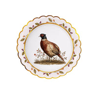 Pheasant plate layered on a mulberry-wreath plate, the game bird framed by the green-and-berry wreath border.