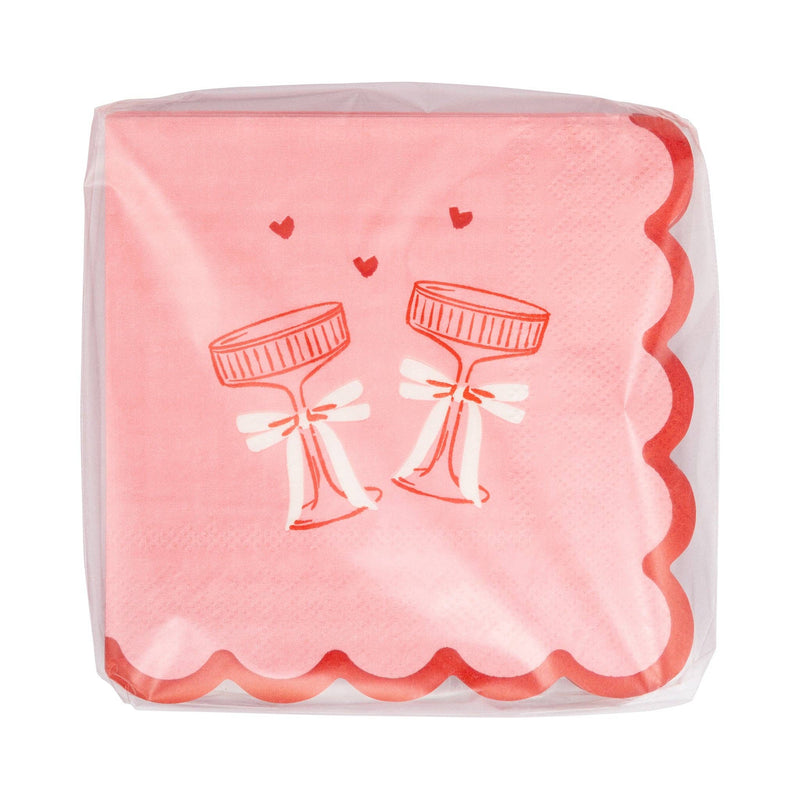 This photo shows a stack of pink clink glasses cocktail napkins packaged in clear wrapping.
