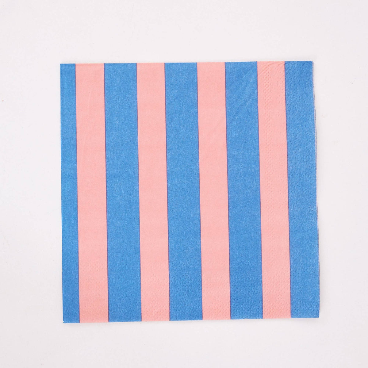 Single pink and blue cabana stripe paper lunch napkin flat on white