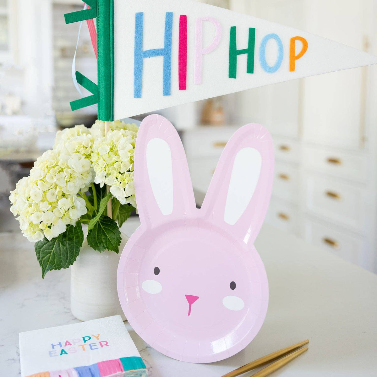 Pink bunny plate styled on Easter table with felt pennant and spring decor.